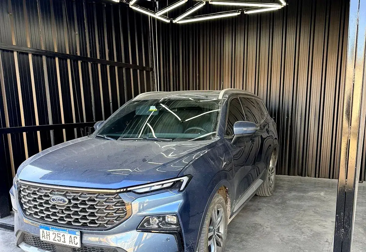 Un auto dentro del box de trabajo, con luces de taller